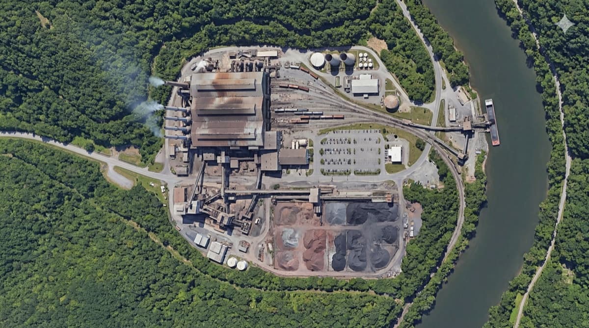 Example facility map with Main Gate, South Gate, processing plant, rail yard, parking, river dock, material storage, and storage tanks connected by internal roads